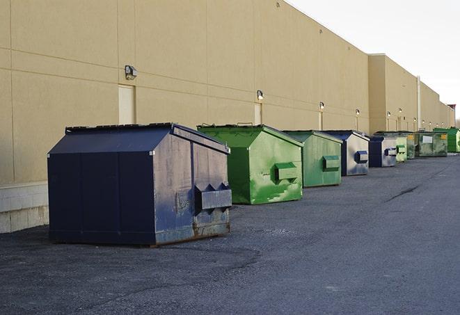 a compact construction dumpster being emptied by a waste disposal truck in Cammack Village